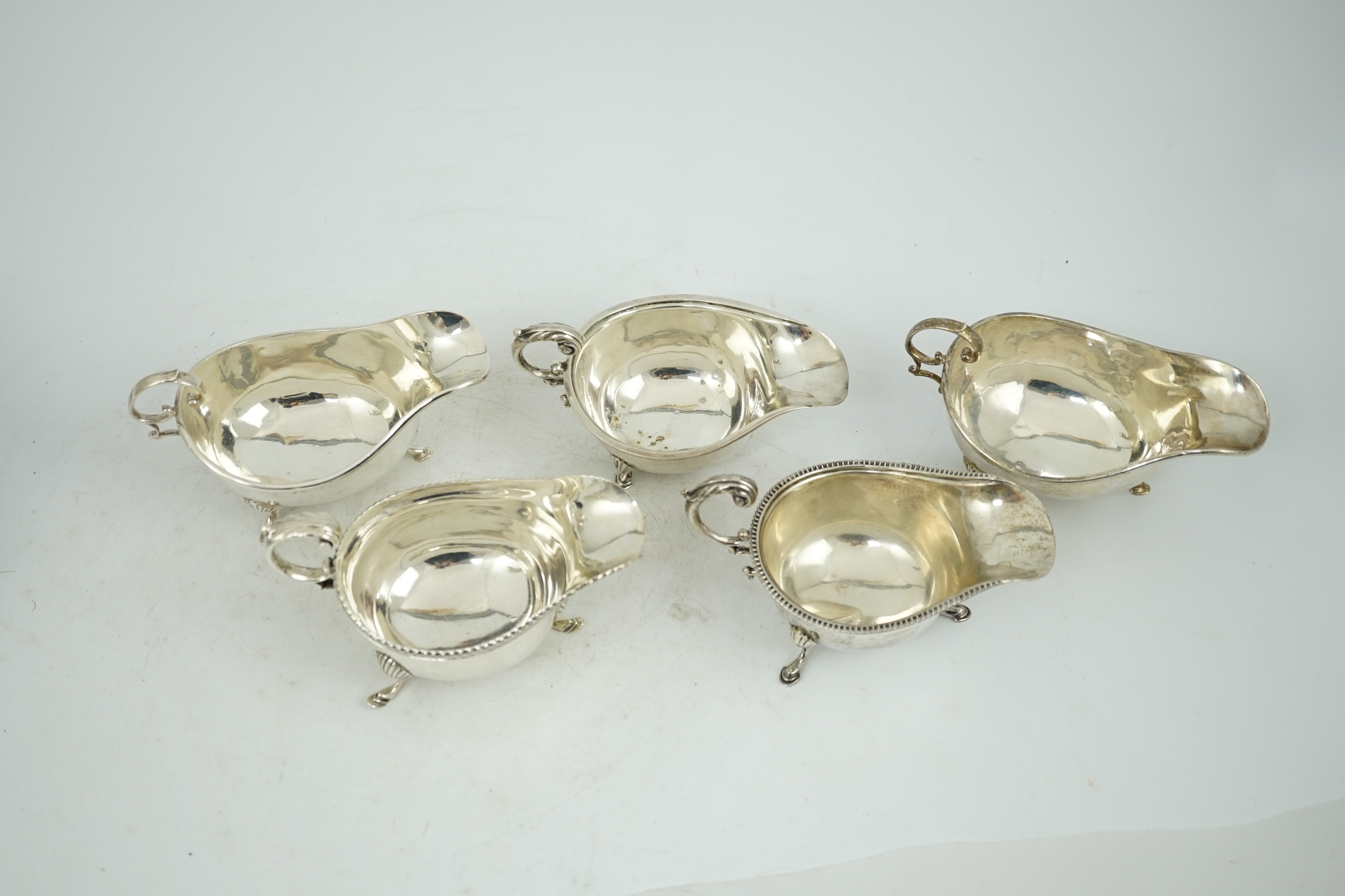 Five assorted early 20th century and later silver sauce boats, various dates and makers, 21.3oz.